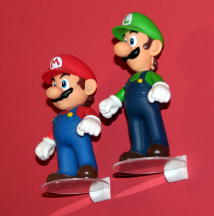 Mini-étagères invisibles portant les figurines Mario et Luigi contre un mur rouge